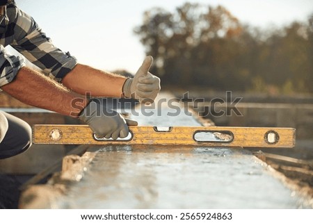 Leveler tool. Close up view of worker on the construction site.
