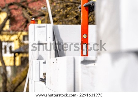 leveling bricks with the help of a spirit level during the construction of the wall of the house