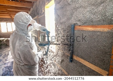 Leveling the wall after applying cellulose insulation to it
