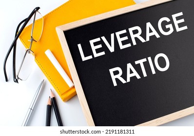 LEVERAGE RATIO Text On A Blackboard With Notepad , Pen, Pencil
