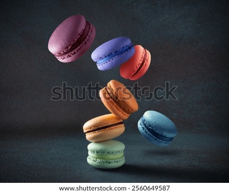 Levitating colored macaroons with various flavors on a dark background