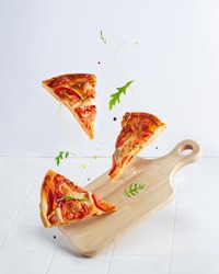Levitating Margherita Pizza Slices With Flying Arugula, Butter And Pepper