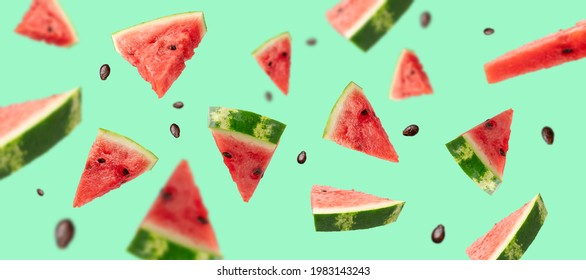 Levitation of ripe pieces of watermelon. Green summer background - Powered by Shutterstock