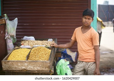 Lewduh/ Bara Bazar, Shillong, Meghalaya / India - August 13, 2019 : A young man is seen selling roasted salted peanuts and chickpeas as a ready to eat snack.
