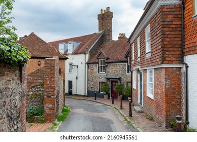 Lewes, East Sussex, United Kingdom - April 22nd 2022: Picturesque scenic old street with traditional downland flint walls and red clay cladding tiles in Lewes, East Sussex, England