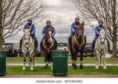 LEXINGTON, KENTUCKY/USA - APRIL 19, 2018: Four Mounted Police Officers Keep Watch Near A Parking Lot On A Chilly Afternoon In Spring At Keeneland Race Course.