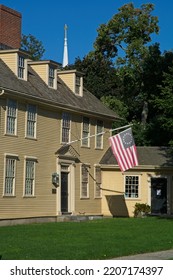 Lexington MA, USA — September 14, 2022: 18th Century Buckman Tavern At Lexington Green. The Minutemen Militia Gathering Place Of 1775. Betsy Ross Flag Of USA Flys Over Doorway.