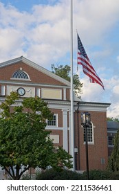 Lexington MA, USA — September 14, 2022: Cary Memorial Hall,  American Flag Waving At Half Mast In Honor Of The Death Of Queen Elizabeth II. Colonial Styled Building Dedicated To Isaac   Harris Cary