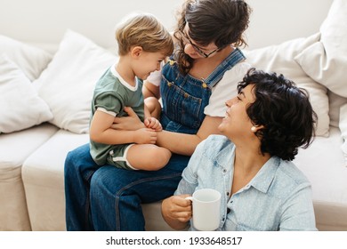 LGBT couple with son at home. Loving lesbian couple playing with their son while spending time together at home.