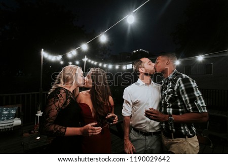 LGBT couples kissing at a party