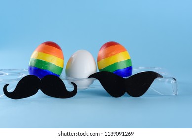 Lgbt Family. Eggs With Lgbt Flag Color And White Baby Egg On Blue Background. Creative Idea For Illustration Surrogacy Law, Right Homosexual Couple Adoption And Raising A Child.
