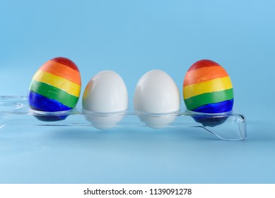 Lgbt Family. Eggs With Lgbt Flag Color And Two White Baby Egg Twins On Blue Background. Creative Idea For Illustration Surrogacy Law, Right Homosexual Couple Adoption And Raising A Child.
