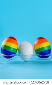 Lgbt Family. Eggs With Lgbt Flag Color And White Baby Egg On Blue Background. Creative Idea For Illustration Surrogacy Law, Right Homosexual Couple Adoption And Raising A Child.
