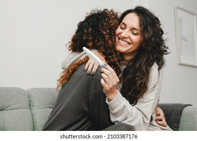 LGBT Lesbian Couple Celebrating With Pregnancy Test At Home - Gay Love Concept