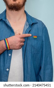 LGBT Pin Badge In Heart-shaped On Denim Blue And Male Forefinger. Concept Of Celebration Of LGBTQ Pride Flag Day And People Rights