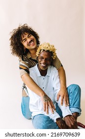 LGBTQ+ Couple Smiling Cheerfully In A Studio. Two Young Male Lovers Embracing Each Other Against A Studio Background. Romantic Young Gay Couple Posing Together Confidently.