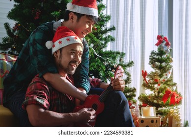 Lgbtq couple smiling hugging, gay male couples have a great Christmas at home, morning before Xmas, Christmas and Happy Holiday Concept - Powered by Shutterstock