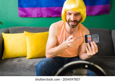 LGBTQ lifestyle vlogger showing beauty products. Putting on makeup for a video tutorial during a live stream  - Powered by Shutterstock