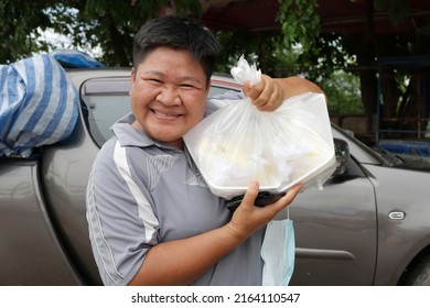 Lgbtq Short Hair Asian Woman Smiling Happy Holding A Bag Of Food