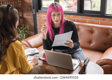 LGBTQ+ transgender man Beautiful Authentic Specialist with Pink Hair and Non-binary trans working together Working Design in creative workplace team work colleagues Gender equality. - Powered by Shutterstock