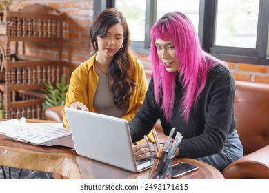 LGBTQ+ transgender man Beautiful Authentic Specialist with Pink Hair and Non-binary trans working together Working Design in creative workplace team work colleagues Gender equality. - Powered by Shutterstock