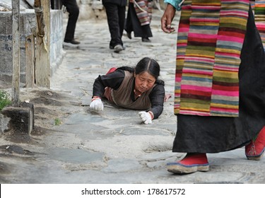LHASA - JUNE 5: Unidentified Tibetan pilgrim circles the Potala palace on June 5, 2013 in Lhasa, Tibet. Some devotees engage in the act of prostration for the whole day.
