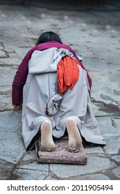 LHASA, TIBET, CHINA - AUGUST, 17 2018: Female pilgrim lying on the floor after prostrating herself. Doing the "Barkhor Kora", a devotional pilgrim circuit around the exterior of the old Jokhang Temple