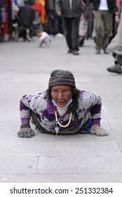 LHASA, TIBET - MAY 15: Tibetan pilgrim circles the holy Jokhang monastery on May 15, 2012 in Lhasa, Tibet. Here a devotee performs full body prostration for an entire day. 