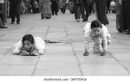 LHASA, TIBET - MAY 2: Tibetan pilgrims circle the holy Jokhang monastery on May 2, 2013 in Lhasa, Tibet. Here devotees performs full body prostration for an entire day. 