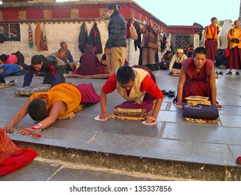 LHASA, TIBET-NOVEMBER 11: Pilgrims prayer and prostration in front of the Jokhang temple. This historic temple is the holiest site in Tibetan Buddhism. November 11, 2004 in Lhasa, Tibet