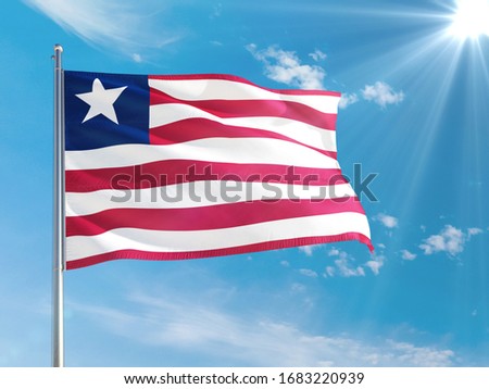 Liberia national flag waving in the wind against deep blue sky. High quality fabric. International relations concept.