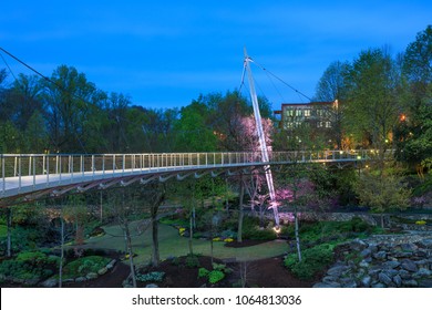 The Liberty Suspension Cable Bridge for pedestrians spans Reedy River, overlooks a water fall and gardens of Falls Park and is a unique symbol of the downtown revitalization efforts in Greenville, SC.