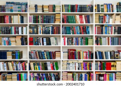 Library with bookcases. Many different books on the shelves. Large selection of books in a bookcase. Blur background.
