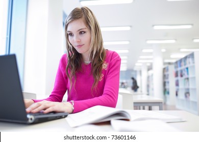 in the library - pretty, female student with laptop and books working in a high school/university library (color toned image) - Powered by Shutterstock