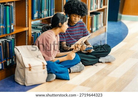 Library study area with students sitting on floor reading textbooks showing modern learning habit academic focus education lifestyle.