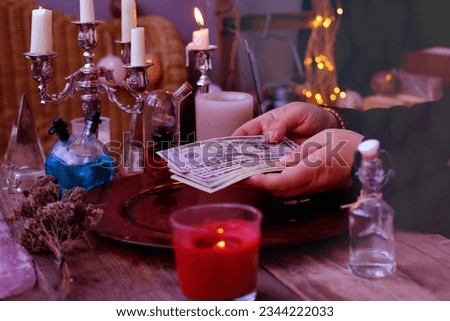 Librate with money, female hands of psychic doing witchcraft passes with dollars, esoteric Oracle performs ritual of removing spell of black magic, esoteric business, magic to increase income Foto stock © 