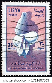 LIBYA - CIRCA 1964: A Stamp Printed In Libya Shows Moth Emerging From Cocoon, Veiled And Modern Women, To Honor Libyan Women In A New Epoch, Circa 1964