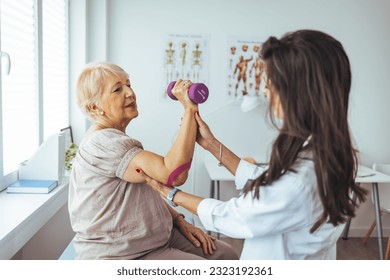 Licensed chiropractor examining senior woman's arm in office of modern well-equipped clinic. Professional physiotherapist helping female patient to cure health problems and recover after elbow injury - Powered by Shutterstock