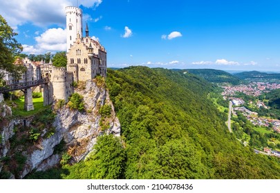 Lichtenstein Castle on mountain top in summer, Germany, Europe. This famous castle is landmark of Schwarzwald, Baden-Wurttemberg. Scenic view of fairytale Lichtenstein Castle and city in distance.  - Shutterstock ID 2104078436