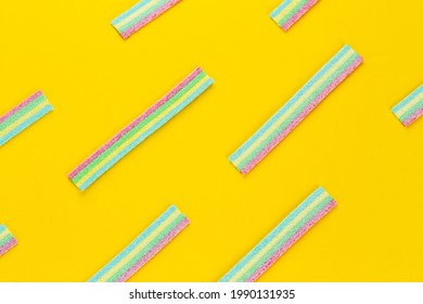 Licorice Candy. Sweet gummy sticks with different flavor, on yellow background. Top view.