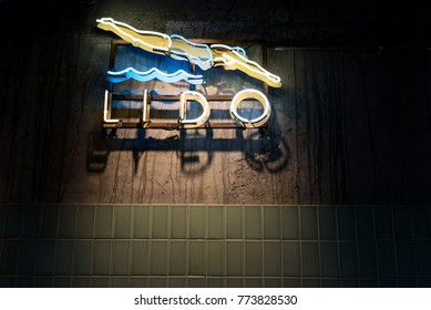 Lido Swimming Pool Sign With A Woman Diving Into Wavy Water In A Neon Light Style