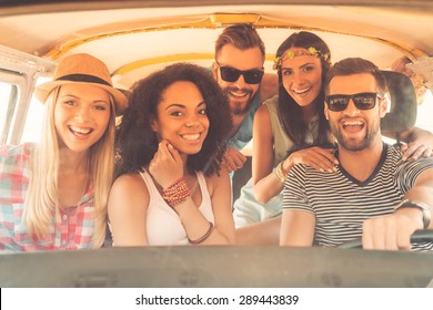 Life Is Better When Friends Are Near. Group Of Joyful Young People Smiling At Camera While Sitting Inside Of Minivan Together