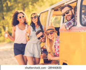 Life Is Brighter When Friends Are Near. Group Of Cheerful Young People Enjoying Time Together While Sitting And Standing Near Their Retro Minivan 