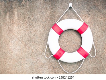 Life Buoy attached to a pebble wall with plenty of copy space