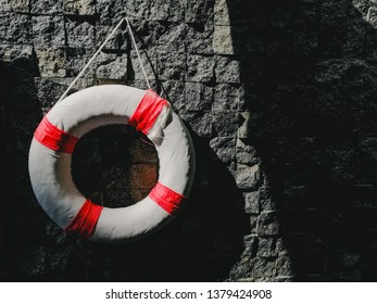 Life Buoy Attached Stone Wall In A Swiming Pool. Close Up