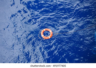 Life buoy bound with rope rescue floating in the blue sea.