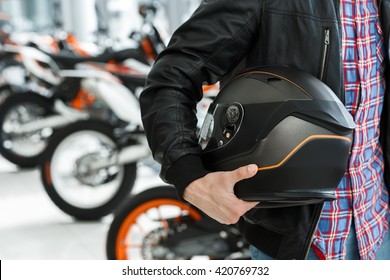 Life Care. Closeup Cropped Shot Of A Male Customer Holding A Black Matte Motorcycle Helmet Posing Near A Motorbike