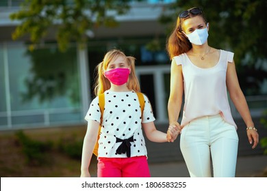 Life During Covid-19 Pandemic. Modern Mother And Child With Masks Coming Back From School Outside.