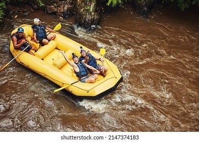 Life Is Either A Daring Adventure Or Nothing At All. Shot Of A Group Of Friends Out River Rafting On A Sunny Day.