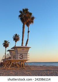 Life guard tower with palm trees as the sun sets in California 